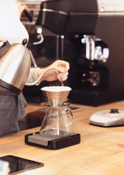 Hand drip coffee, Barista pouring water on coffee ground with filter. Barista, cafe, making coffee, preparation and service concept. Hipster syile