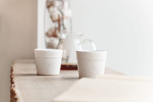 Cup of coffee, cake, wooden windowsill. In the background white window.