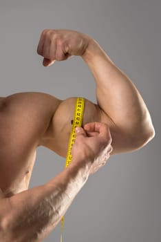 Man's strong arm with measuring tape isolated