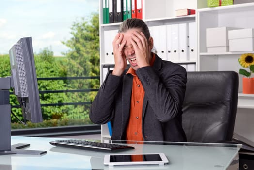 young tired business man with head in hands is over-worked