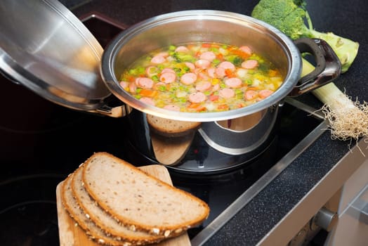 vegetable soup in pot on stove with leek and bread