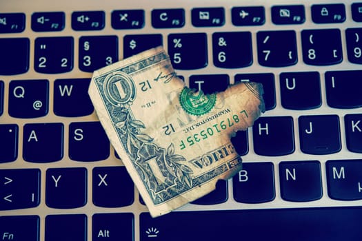 still life- computer keyboard with burned dollar bank notes