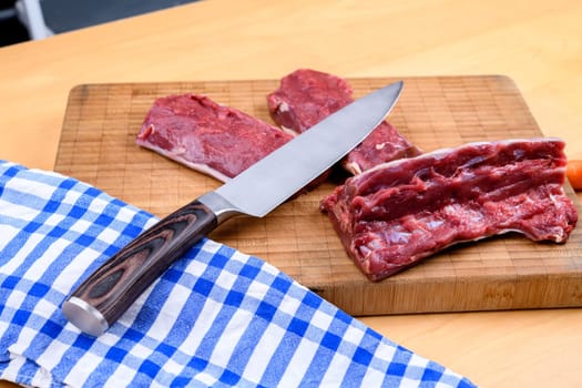 saddle of venison on wooden board with big knife