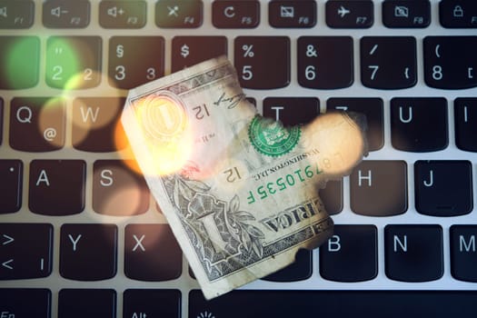 still life- computer keyboard with burned dollar bank notes
