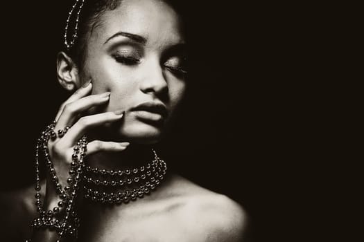 Upscale Indian woman wearing chain jewellery and beautiful makeup. Black and white photo. Mysterious beauty expressions.