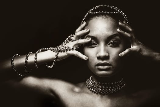 Upscale Indian woman wearing chain jewellery and beautiful makeup. Black and white photo. Mysterious beauty expressions.