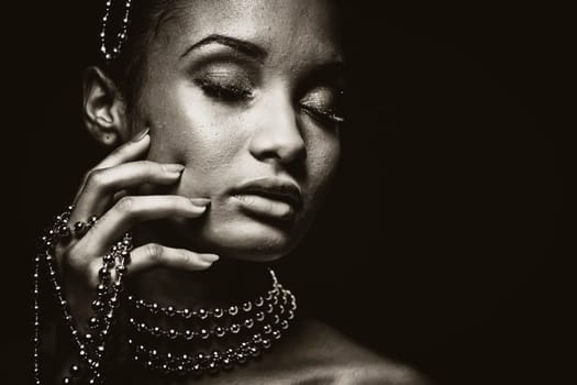 Upscale Indian woman wearing chain jewellery and beautiful makeup. Black and white photo. Mysterious beauty expressions.