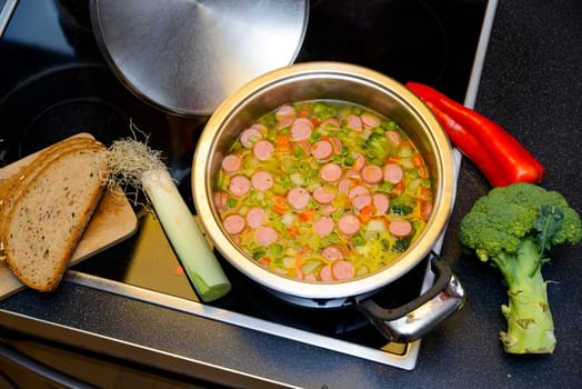 vegetable soup in pot on stove with leek and bread