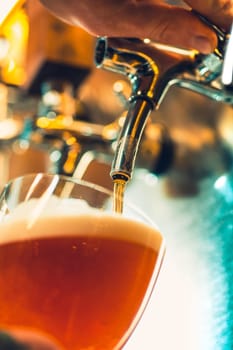 The beer taps in a pub. nobody. Selective focus. Alcohol concept. Vintage style. Beer craft. Bar table. Steel taps. Shiny taps. Glass of beer