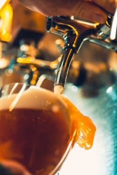 The beer taps in a pub. nobody. Selective focus. Alcohol concept. Vintage style. Beer craft. Bar table. Steel taps. Shiny taps. Glass of beer