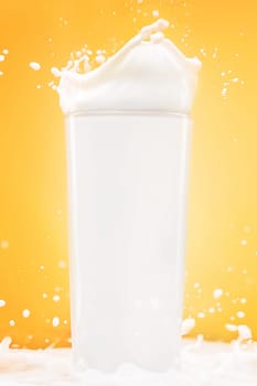 The glass of milk on yellow studio