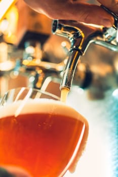 The beer taps in a pub. nobody. Selective focus. Alcohol concept. Vintage style. Beer craft. Bar table. Steel taps. Shiny taps. Glass of beer