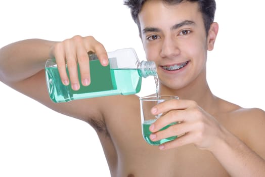 Cute teenager with white background, wearing braces on his teeth. Use mouthwash for oral hygiene.