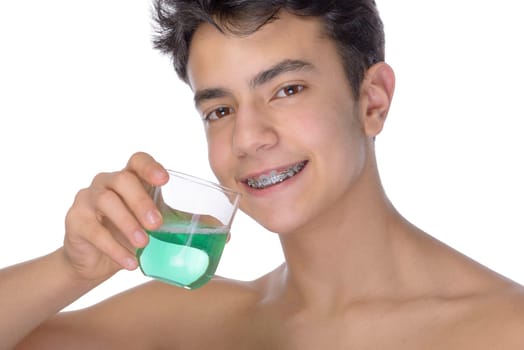 Cute teenager with white background, wearing braces on his teeth. Use mouthwash for oral hygiene.