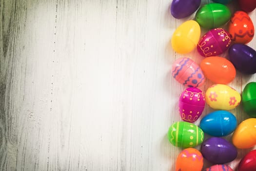 Multi colored Easte eggs on white wooden background