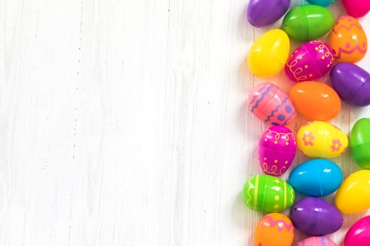 Multi colored Easte eggs on white wooden background