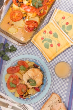 Traditional portuguese meal of fish with potatoes and tomato, made on the oven.
