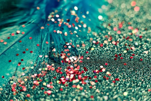 Soft feather with sparkles with artistic bright light and shadows. Soft blurred background of artistic close-up glitter macro image.