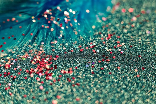 Soft feather with sparkles with artistic bright light and shadows. Soft blurred background of artistic close-up glitter macro image.
