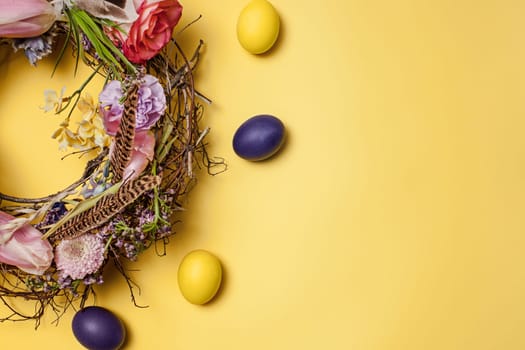 Easter card. Painted Easter eggs in nest on yellow table background. Top view of easter decoration. Happy easter concept. Trendy colors