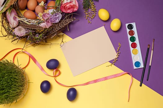 Easter card. Painted Easter eggs in nest on yellow table background. Top view of easter decoration. Happy easter concept. Trendy colors