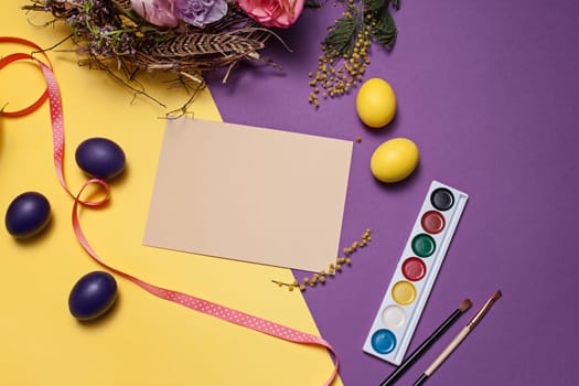 Easter card. Painted Easter eggs in nest on yellow table background. Top view of easter decoration. Happy easter concept. Trendy colors
