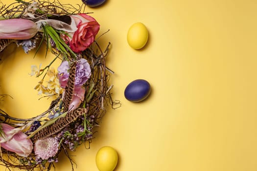 Easter card. Painted Easter eggs in nest on yellow table background. Top view of easter decoration. Happy easter concept. Trendy colors