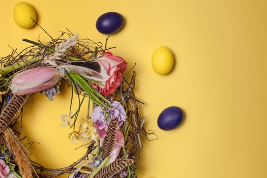 Easter card. Painted Easter eggs in nest on yellow table background. Top view of easter decoration. Happy easter concept. Trendy colors