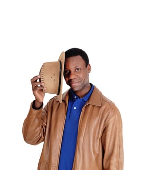 A good looking African American man holding his brown cowboy.hat, standing in a leather jacket, isolated for white background.