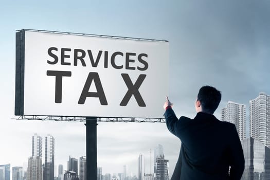 Rear view of businessman pointing at billboard with Services tax sign. Goods and Services Tax concept.