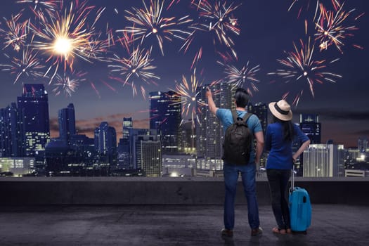 Young asian couple enjoying fireworks on the city at night