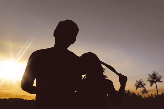 Silhouette of father and daughter posing together with sunset background