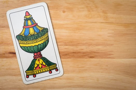 Cups ace italian card on a wood background