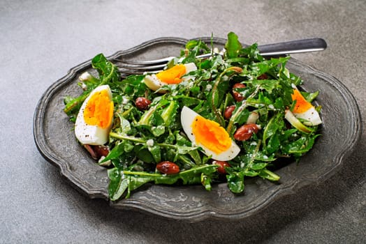 Fresh healthy dandelion salad with eggs and beans close up