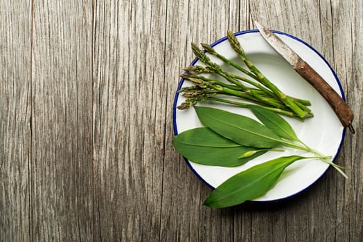 Spring food with wild garlic and asparagus on wooden background