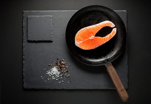 Slice of red salmon fish with spices in pan. Prepare for cooking meal.