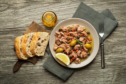 Tuna salad with beans and olive oil on wooden table