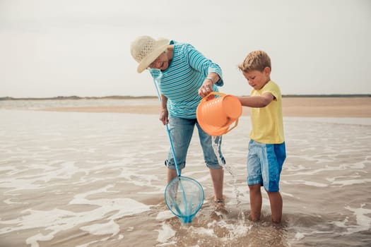 Searching for sea artifacts with a bucket and fishing rod at the beach with grandma.