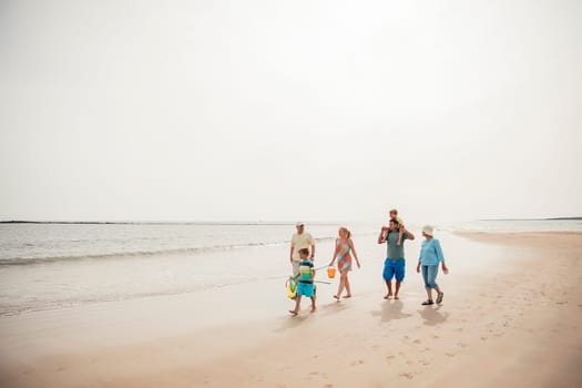 Wide angle view of a family walking along the beach.