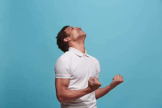 I won. Winning success happy man celebrating being a winner. Dynamic image of caucasian male model on blue studio background. Victory, delight concept. Human facial emotions concept. Trendy colors