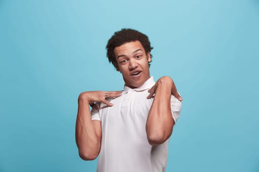 Argue, arguing concept. Beautiful male half-length portrait isolated on blue studio backgroud. Young emotional surprised man looking at camera. Human emotions, facial expression concept. Front view