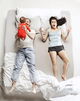 Top view of happy funny family with one newborn child in bedroom. Enjoying being together. Happy family in bed. Top view. Emotions concept. Morning after sleep. Family lifestyle. happy parents concept