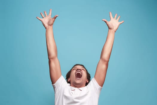I won. Winning success happy man celebrating being a winner. Dynamic image of caucasian male model on blue studio background. Victory, delight concept. Human facial emotions concept. Trendy colors