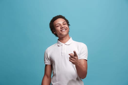 I choose you and order. The smiling business man point you, want you, half length closeup portrait on blue studio background. The human emotions, facial expression concept. Front view. Trendy colors