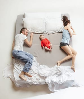 Top view of happy funny family with one newborn child in bedroom. Enjoying being together. Happy family in bed. Top view. Emotions concept. Morning after sleep. Family lifestyle. happy parents concept