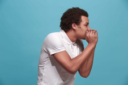 Do not miss. Young casual man shouting. Shout. Crying emotional man screaming on blue studio background. male half-length portrait. Human emotions, facial expression concept. Trendy colors