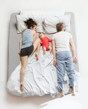 Top view of happy funny family with one newborn child in bedroom. Enjoying being together. Happy family in bed. Top view. Emotions concept. Morning after sleep. Family lifestyle. happy parents concept