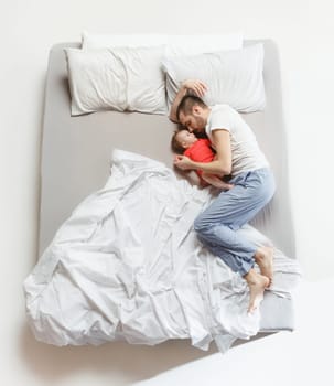 Top view of happy funny family with one newborn child in bedroom. Enjoying being together. Happy family in bed. Top view. Emotions concept. Morning after sleep. Family lifestyle. happy parents concept