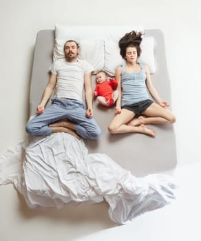 Top view of happy funny family with one newborn child in bedroom. Enjoying being together. Happy family in bed. Top view. Emotions concept. Morning after sleep. Family lifestyle. happy parents concept