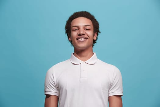 Happy business man standing and smiling isolated on blue studio background. Beautiful male half-length portrait. Young emotional man. The human emotions, facial expression concept. Front view.